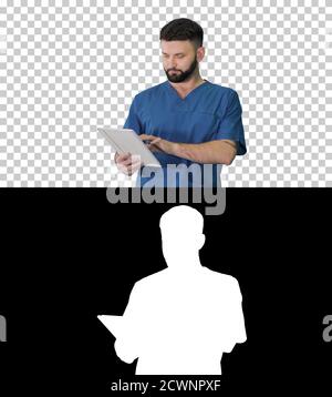Confident concentrated focused surgeon using digital tablet, Alp Stock Photo