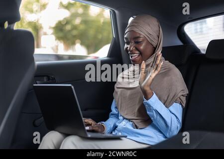 Online Business Meeting. Muslim businesswoman making video call with laptop in car Stock Photo
