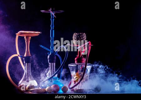Hookah smoking on the background of an empty grunge wall, neon light, smoke, smog Stock Photo
