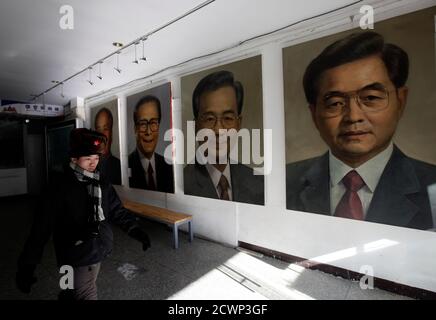 A man walks past the portraits (R-L) of China's President Hu Jintao, Premier Wen Jiabao , former President Jiang Zemin and Chairman Mao Zedong by Chinese artist Ye Zhifu outside a gallery in Beijing, January 18, 2011. Hu arrives in the United States on Tuesday for a four-day visit, with the centerpiece of the trip a formal state visit on Jan. 19 at the White House. REUTERS/Jason Lee (CHINA - Tags: POLITICS)