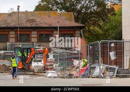 Builders or construction workers using a digger on a construction site Stock Photo