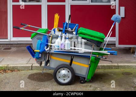 A cleaners trolley with cleaning equipment outside a block of flats Stock Photo