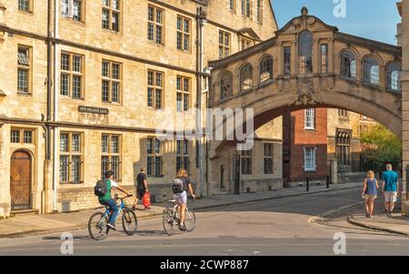 OXFORD CITY ENGLAND PEOPLE AND CYCLISTS AT THE ENTRANCE TO NEW COLLEGE LANE AND VIEW OF HERTFORD BRIDGE OR BRIDGE OF SIGHS Stock Photo