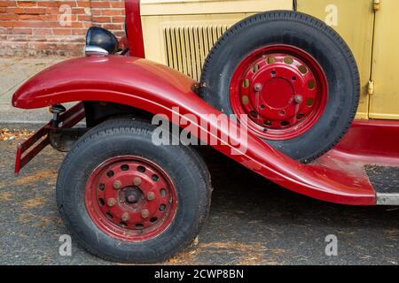The front wheels of a vintage motor car with a spare tyre above Stock Photo
