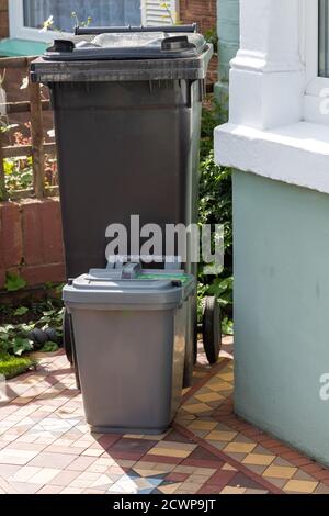 A Black wheelie bin with a food recycling bin outside a home ready for collection Stock Photo