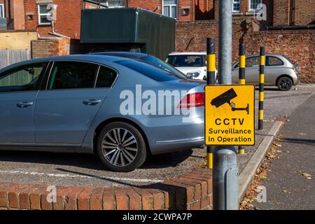 A CCTV in operation sign on a lamppost outside a car park Stock Photo