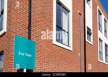 A for sale sign outside a block of modern flats or apartment block Stock Photo