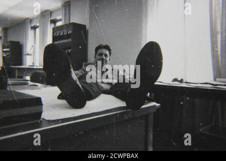 Fine 1970s vintage black and white photography of a funny professional man working on the job at the office. Stock Photo