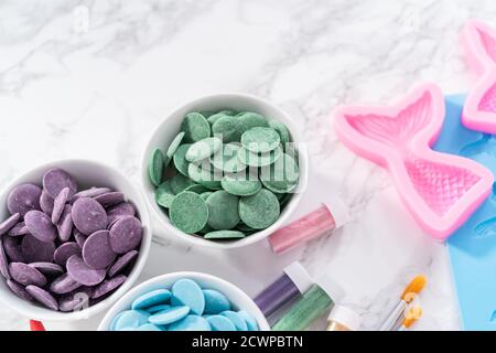 Flat lay. Ingredients to make chocolate mermaid molds from the chocolate chips. Stock Photo