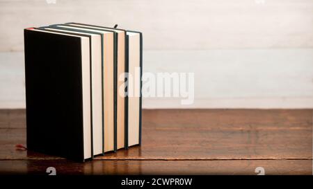 stack of blue books on old wooden shelf with dark background Stock Photo