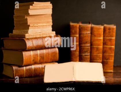 stack of old retro books on old wooden shelf and dark background Stock Photo