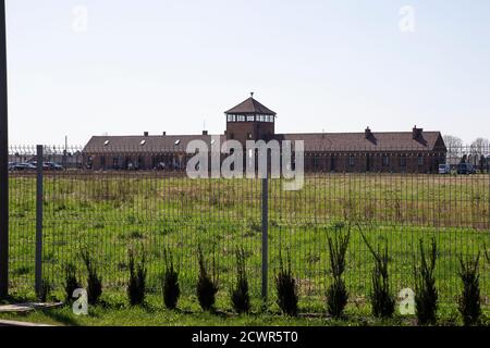 A view over the perimeter fence to the entrance of Birkenau camp at the Auschwitz -Birkenau concentration camp scene of mass murder by Nazi Germany Stock Photo