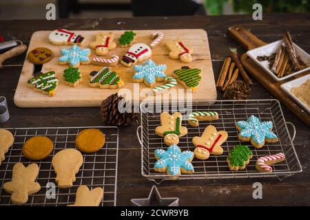 Freshly baked Christmas cookies on wooden table. Top view of xmas tree and snowman biscuits. Stock Photo