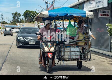 SAMUT PRAKAN, THAILAND, JUN 23 2020, A vendor carries a lot of things on a motorized tricycle on a street. Stock Photo