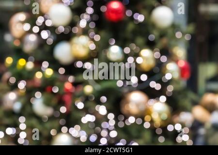 Christmas tree out of focus with glowing lights. Abstract blurred christmas background with defocused lights. Festive backdrop. Merry Christmas, Happy Stock Photo