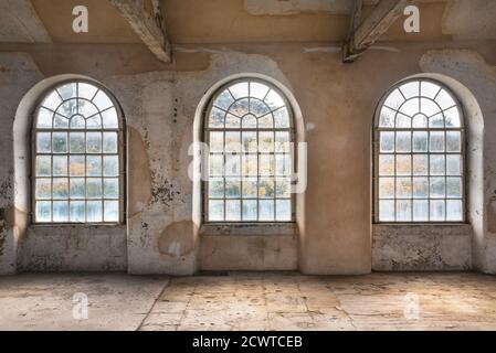 Three arched windows in a disused textile mill Stock Photo