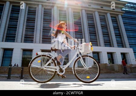 A woman rides her bicycle past Romania's National Library during its official opening ceremony in Bucharest April 23, 2012. Opened in a refurbished communist era building, Romania's National Library has a fund of more than 12 million books. REUTERS/Bogdan Cristel (ROMANIA - Tags: SOCIETY EDUCATION TRANSPORT)