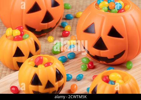 Halloween decorations using plastic pumkins and jelly beans on a wooden background Stock Photo