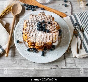 freshly baked homemade waffles heart-shaped with blueberries stacked on a plate Stock Photo