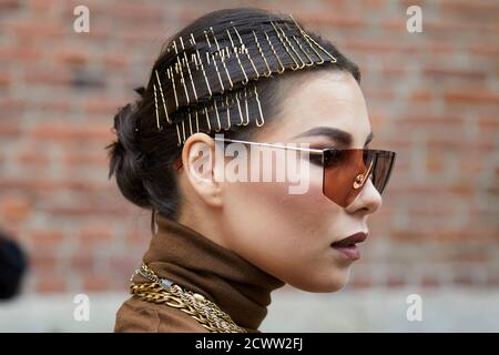 MILAN, ITALY - SEPTEMBER 24, 2020: Woman with hairstyle with golden hair clips before Max Mara fashion show, Milan Fashion Week street style Stock Photo