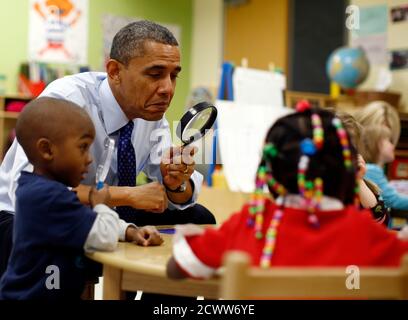 U.S. President Barack Obama uses a magnifying glass to play a game with children in a pre-kindergarten classroom at College Heights early childhood learning center in Decatur February 14, 2013. Obama flew to Georgia to push his plan to ensure high-quality preschool, unveiled during his State of the Union address this week.  REUTERS/Jason Reed   (UNITED STATES - Tags: POLITICS EDUCATION TPX IMAGES OF THE DAY)