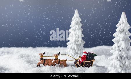 Santa Claus in a sleigh with reindeer in the snowy forest. Christmas greeting card. Stock Photo