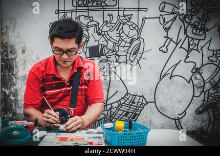 Young Asian man creating an artwork on the street Stock Photo