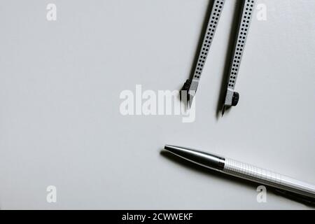 A pair of compasses and a pen on white background Stock Photo