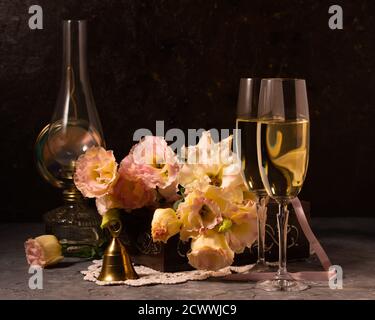 Still life with flowers, glasses and a kerosene lamp Stock Photo