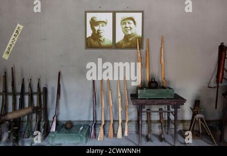 Wooden guns are placed next to portraits of late Chairman Mao Zedong (R) and late commander-in-chief Zhu De at the Eighth Route Army Culture Park, one of two theme parks, in Wuxiang county, north China's Shanxi province, October 20, 2012. Visitors to the theme parks pay to participate in a dress up action play with performers, where they can choose to role play as soldiers from the Japanese army or the Eighth Route Army, with professional sound and lighting effects. A live-action show and the parks, located near the former headquarters of the Eighth Route Army, a military group controlled by t