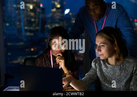 Business people working late at laptop in office Stock Photo