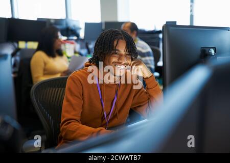 Smiling businessman working at computer in office Stock Photo