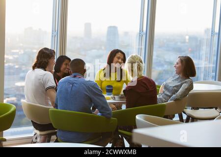 Smiling business people talking over lunch in urban cafeteria Stock Photo