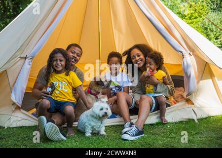 Portrait happy family with dogs in camping tent Stock Photo