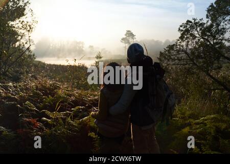 Silhouette young couple hiking and enjoying tranquil nature view Stock Photo