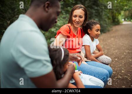 Happy family resting on trail in park Stock Photo
