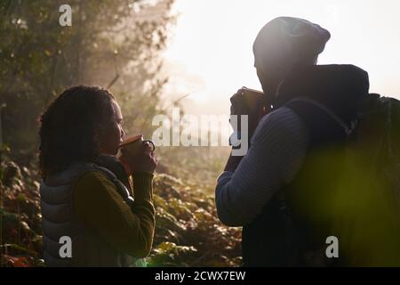 Silhouette young couple drinking coffee in autumn nature Stock Photo