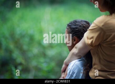 Affectionate mother and daughter hugging in nature Stock Photo