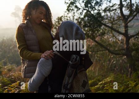 Happy affectionate hiking couple hugging in woods Stock Photo