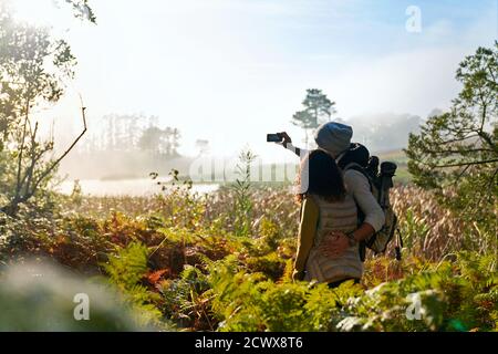 Young hiking couple taking selfie in sunny nature Stock Photo