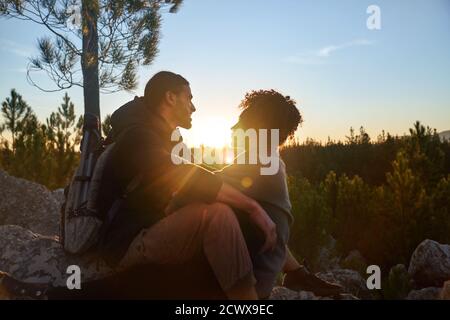 Affectionate young hiking couple enjoying tranquil sunset in woods Stock Photo