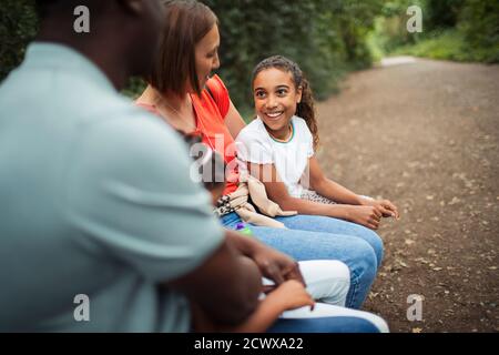 Happy family talking on park bench Stock Photo