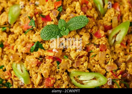 Masala Egg Bhurji or Muttai Podimas close up. Anda Bhurji is indian cuisine scrambled eggs dish with spices. Asian food and meal. Stock Photo