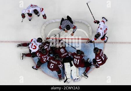 Latvia's goalie Kristers Gudlevskis (C) and Latvia's Kristaps Sotnieks (hidden) combine to make a goal line save from Canada's Patrick Marleau (L) in the third period of their men's quarter-finals ice hockey game at the 2014 Sochi Winter Olympic Games, February 19, 2014.        REUTERS/Gary Hershorn (RUSSIA  - Tags: SPORT OLYMPICS SPORT ICE HOCKEY TPX IMAGES OF THE DAY)