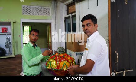 Two Male Movers Wrapping The Home Appliances With Plastic Wrap On Home Background Stock Photo
