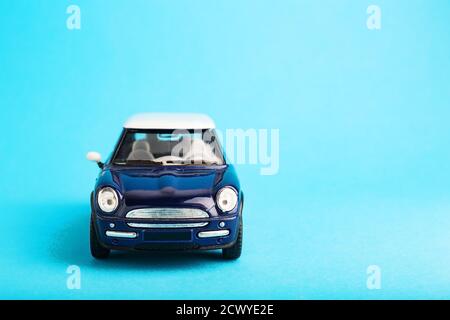Ukraine, Odessa - June 12, 2019: Blue small toy car model on Blue background. Travel concept colored in trendy colors. Vacation trip adventures symbol Stock Photo