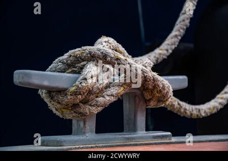 Close up of the dock cleat with a rope tied around it. Connection visual concept as boat tied and linked to the pontoon. Stock Photo