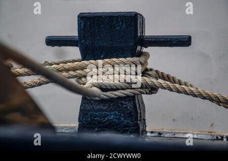 Close up of the boat bollard with a rope tied around it. Connection visual concept as boat tied and linked to the pontoon. Stock Photo