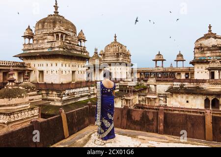 Orchha, Madhya Pradesh, India : An Indian woman in a blue sari stands at one of the balconies of the impressive 17th century Jahangir Mahal palace wit Stock Photo