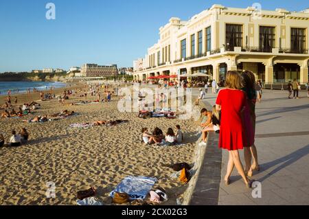 Biarritz, French Basque Country, France - July 19th, 2019 : Two women look at La Grande Plage, the town's largest beach with the Art deco Casino of Bi Stock Photo